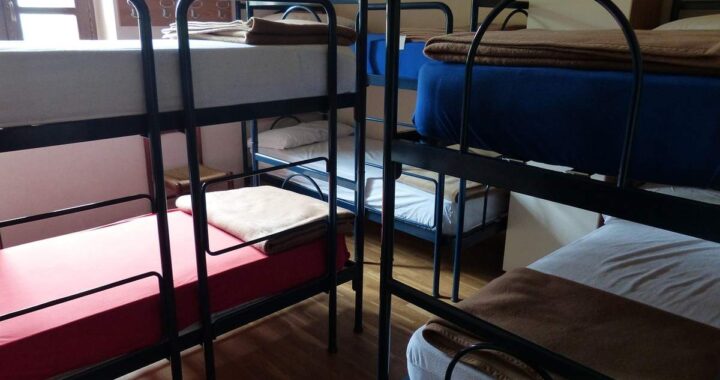 Salle de dortoir avec plusieurs lits superposés et matelas variés