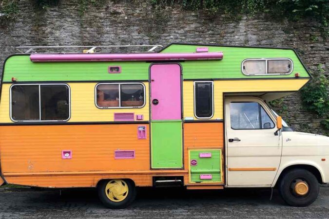 Camion‑caravane vintage aux couleurs vives stationné sur route