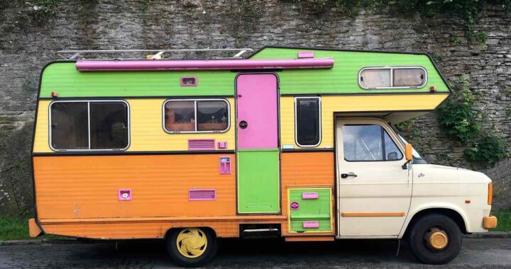 Camion‑caravane vintage aux couleurs vives stationné sur route