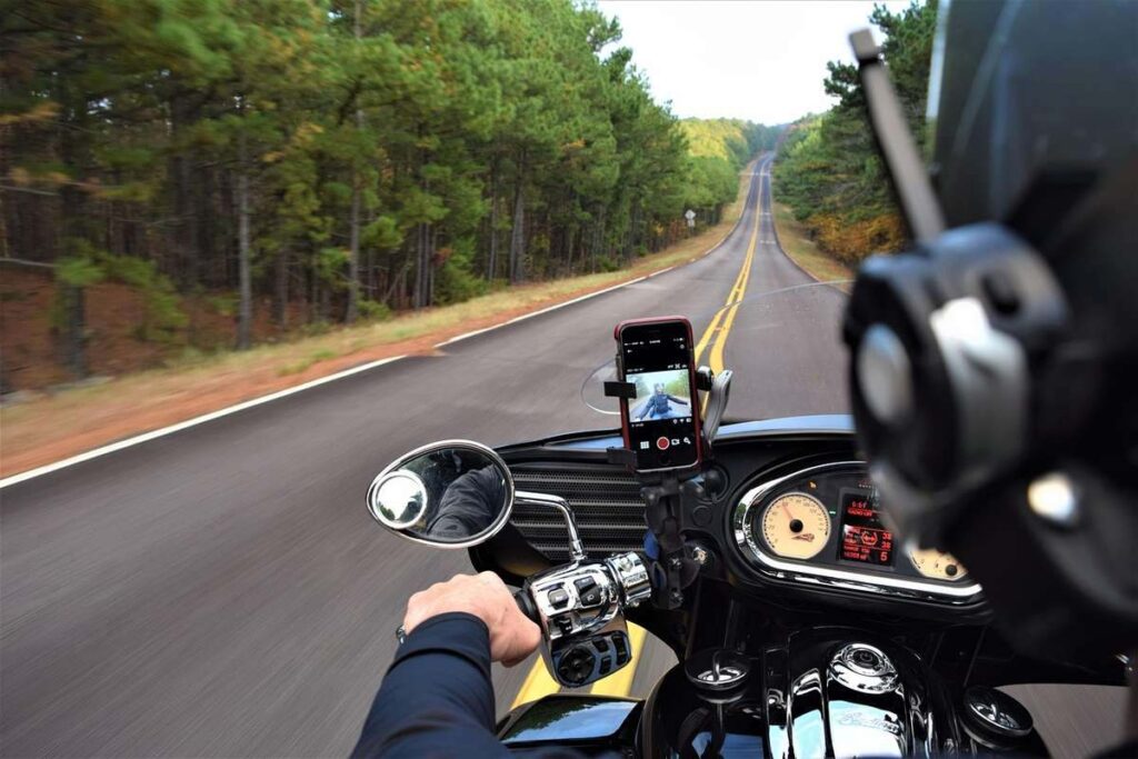 Point de vue du motard roulant sur une autoroute rectiligne bordée de forêts