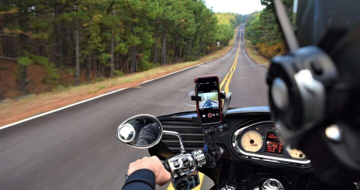 Point de vue du motard roulant sur une autoroute rectiligne bordée de forêts