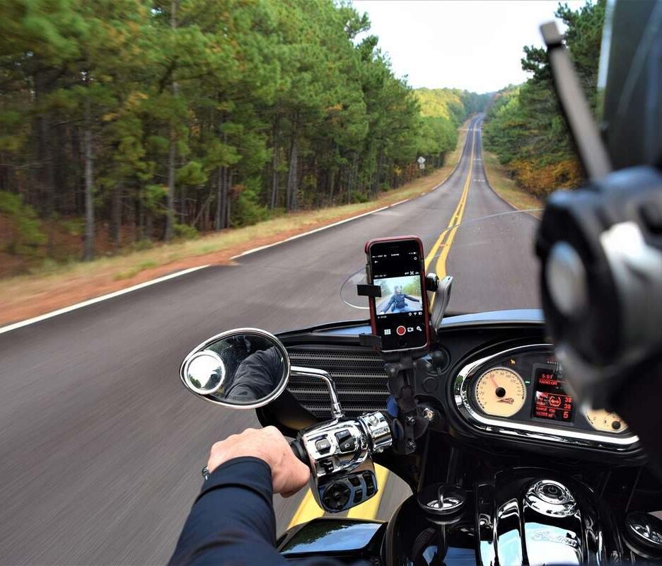 Point de vue du motard roulant sur une autoroute rectiligne bordée de forêts