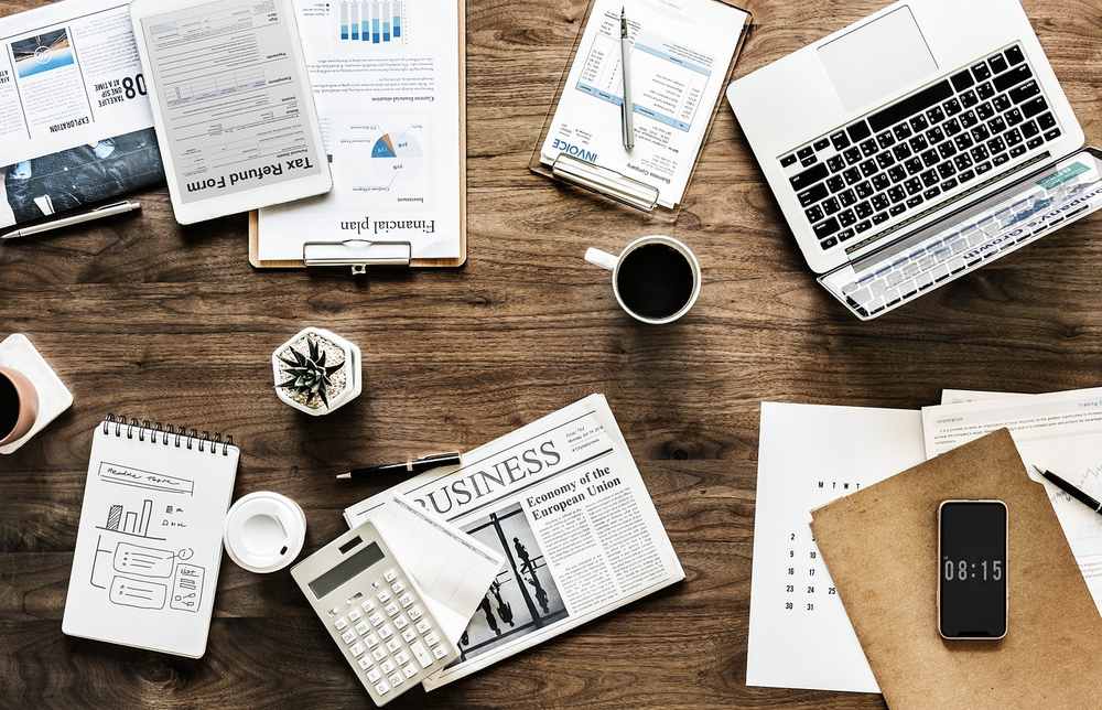 Plateau en bois avec ordinateur, documents, café et smartphone Plateau en bois avec ordinateur, documents, café et smartphone