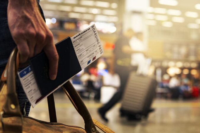 Main tenant passeport et carte d'embarquement à l'aéroport. Voyageur avec valises. Activité de voyage