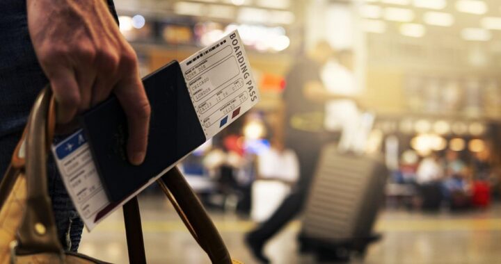 Main tenant passeport et carte d'embarquement à l'aéroport. Voyageur avec valises. Activité de voyage