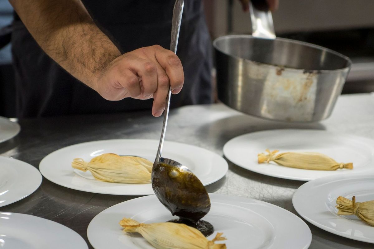 Chef versant sauce sur assiette avec plat de cuisine Chef versant sauce sur assiette avec plat de cuisine