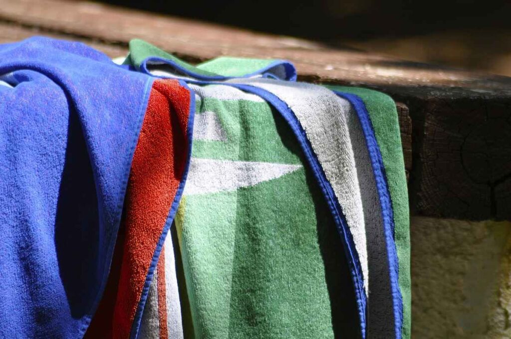 Serviettes de bain colorées sur un rebord de piscine