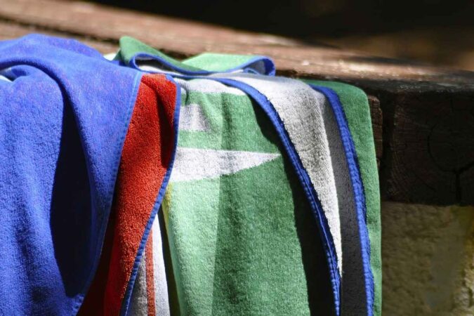 Serviettes de bain colorées sur un rebord de piscine
