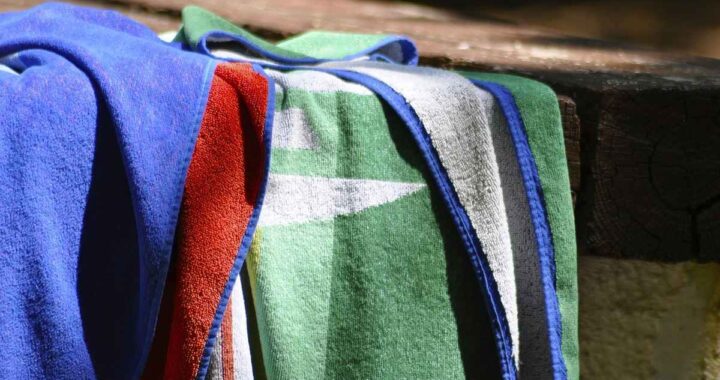 Serviettes de bain colorées sur un rebord de piscine
