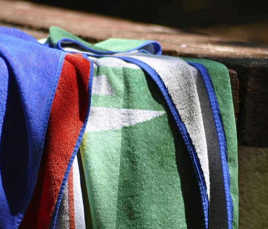 Serviettes de bain colorées sur un rebord de piscine