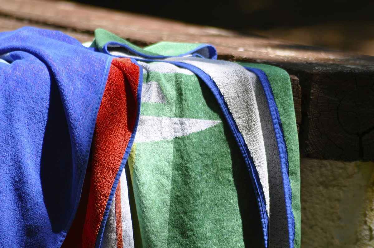 Serviettes de bain colorées sur un rebord de piscine