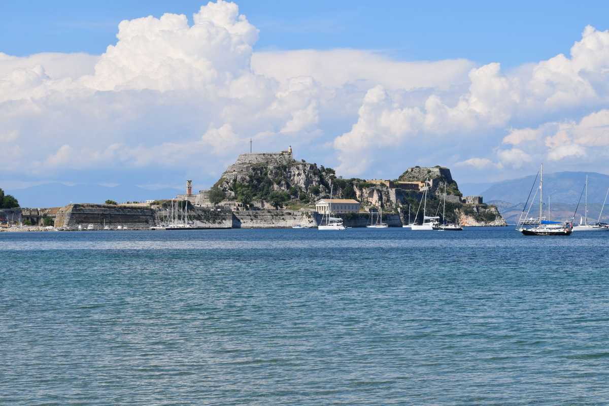 Vue du port avec bateaux, île fortifiée sous ciel nuageux Vue du port avec bateaux, île fortifiée sous ciel nuageux